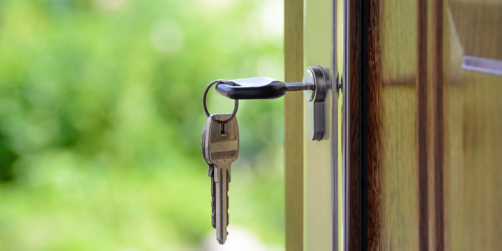 keys on a keyring with one inserted in a door lock
